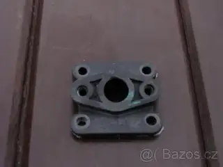 Plastová příruba mezi karburátor a klapky.