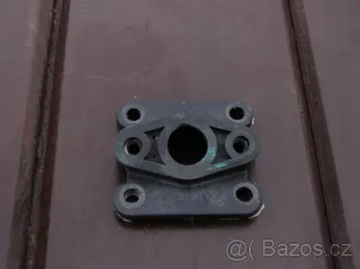 Plastová příruba mezi karburátor a klapky.