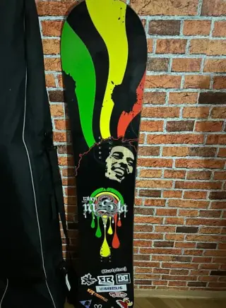 Snowboard s rasta/Bob Marley motivem značky Raven